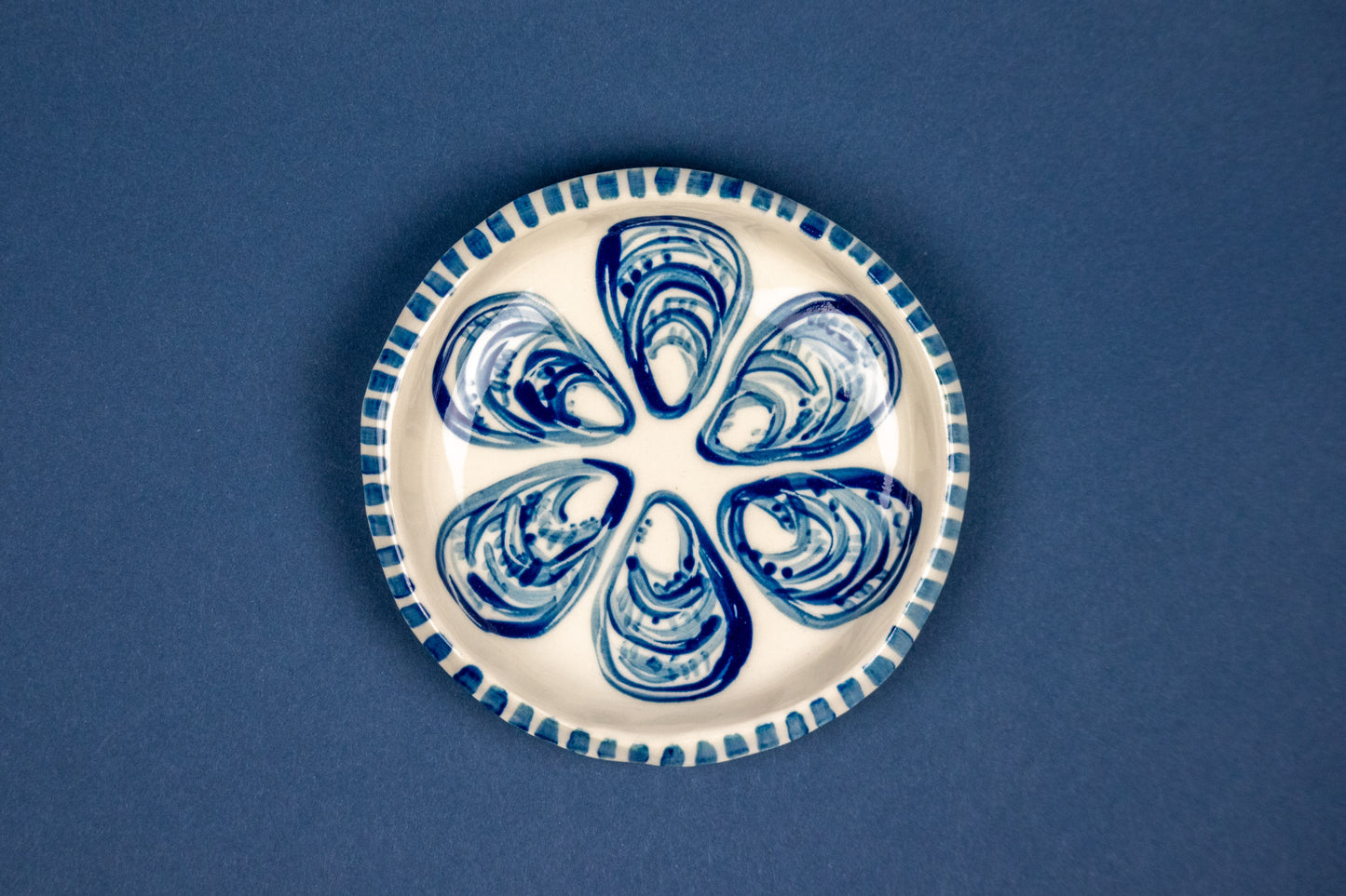 1/2 dozen oysters on a circle dish with striped rim