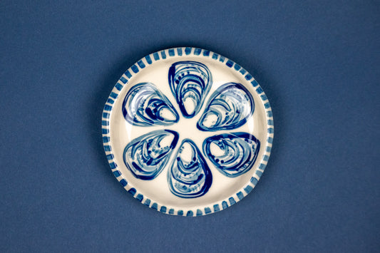 1/2 dozen oysters on a circle dish with striped rim